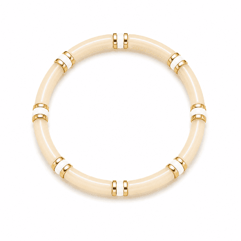 Pulsera elástica de diseño elegante con piezas tubulares y delicados detalles dorados y blancos.