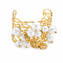 Brazalete tipo cuff con diseño calado, acabado dorado brillante y detalles de perlas y charms marinos. COLOR DORADO