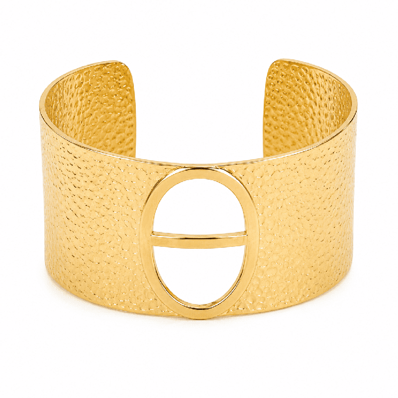 Brazalete tipo cuff con textura martillada y elegante detalle ovalado central color dorado